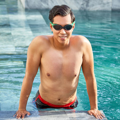 Young man swimming in pool at resort