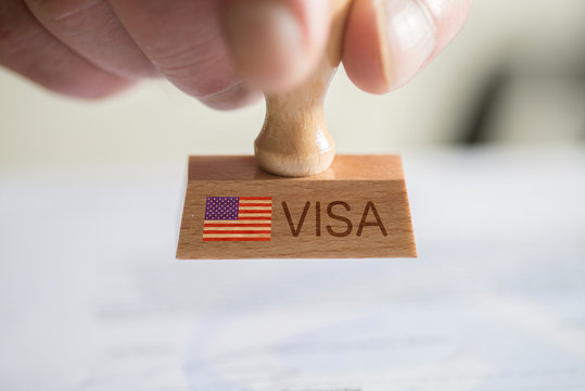 Ein Mann und ein Stempel mit dem Visum f&uuml;r USA