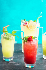 Group of cold soft drinks and pitcher full of refreshing lemonade with copy space.