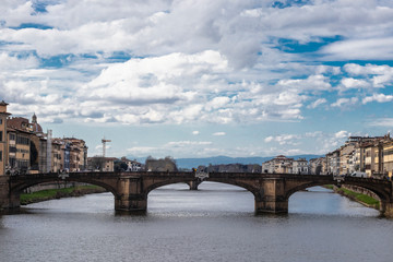 Fototapeta premium Old stone bridge in Firenze river skyline over a cloudscape, Italy