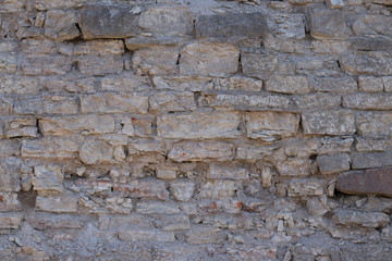 wall of an old crumbling grey stone blocks
