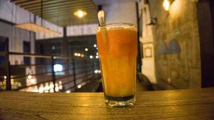 colorful and cold fresh fruit drink on a wooden table. cafe atmosphere at night