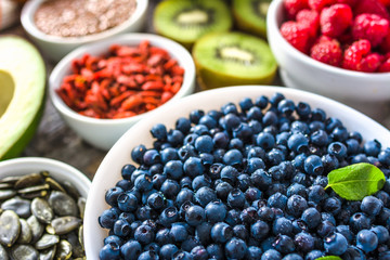 Bowl with blueberries and other healthy food for breakfast containing organic superfoods like fresh fruits and seeds. Vegan nutrition concept.