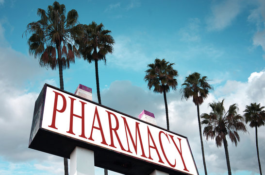 aged and worn pharmacy sign with palm trees