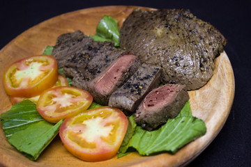Medium roast steak on wooden plate