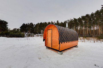 Mobile bath in the form of a wooden barrel. Forest as a background