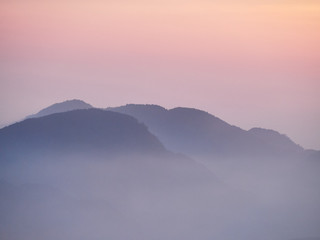 Sun set in Taiwans mountain region - Alishan mountain sun set in warm pastel colors with fog between mountain ranges