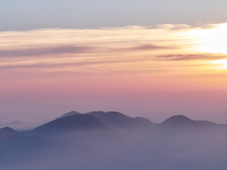 Fototapeta na wymiar Sun set in Taiwans mountain region - Alishan mountain sun set in warm pastel colors with fog between mountain ranges