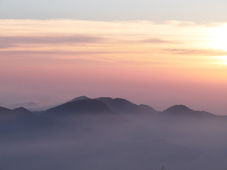 Sun set in Taiwans mountain region - Alishan mountain sun set in warm pastel colors with fog between mountain ranges