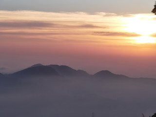 Sun set in Taiwans mountain region - Alishan mountain sun set in warm pastel colors with fog between mountain ranges