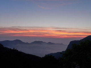 Sun set in Taiwans mountain region - Alishan mountain sun set in warm pastel colors with fog between mountain ranges