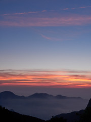 Sun set in Taiwans mountain region - Alishan mountain sun set in warm pastel colors with fog between mountain ranges