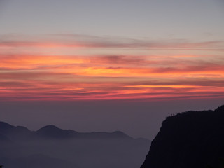 Sun set in Taiwans mountain region - Alishan mountain sun set in warm pastel colors with fog between mountain ranges