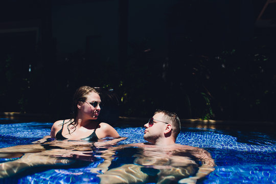 Young couple are relaxing at swimming pool party. Summer vacation concept.