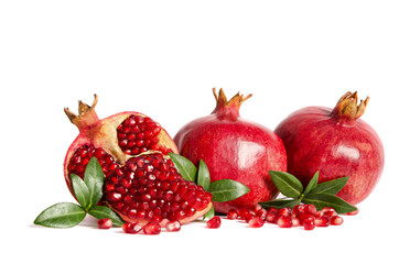 two whole Pomegranates and two parts of Pomegranate with leaves and seeds isolated on white