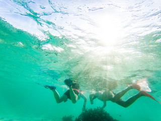 Fototapeta na wymiar couple snorkeling in crystal clear tropical waters