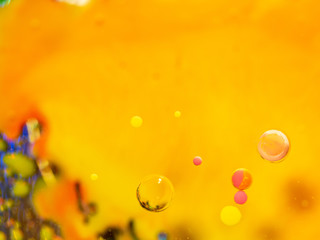 Spheres and multicolour pattern on abstract orange background. Close up macro shot. Blurred background. Selective soft focus. Abstract multicolour universe. Bubbles in space