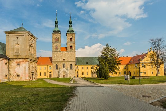 Tepla, Czech Republic / Europe - April 3 2019: Premonstratensian monastery founded in 12th century by Blessed Hroznata, abbey church made of stone with two towers, sunny day, blue sky, clouds, paving