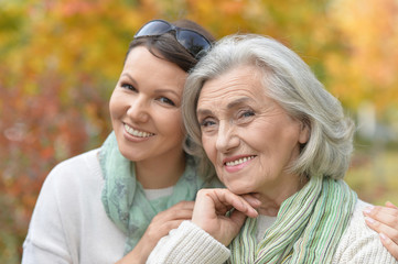 Fototapeta premium Close up portrait of senior woman with adult daughter in autumnal park