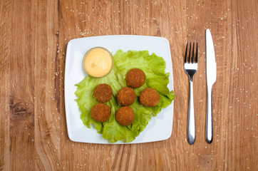 Deep fried cheese balls on the with dish with salad. Tasty dinner