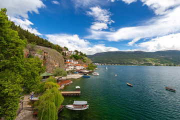 Fototapeta na wymiar Ohrid lake, North Macedonia. Peaceful lake in spring. Small houses are spread over a cliff near path leading to the Saint Johan at kaneo church in Macedonian town ohrid