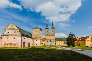 Fototapeta na wymiar Tepla, Czech Republic / Europe - April 3 2019: Premonstratensian monastery founded in 12th century by Blessed Hroznata, abbey church made of stone with two towers, yellow convent, sunny day, blue sky