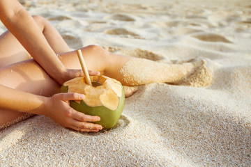 Fototapeta na wymiar Hands with coconut close up on the beach