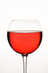 Bright red cocktail against white background