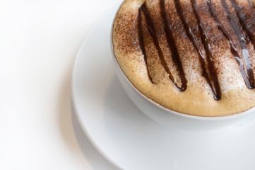The cup of cappuccino on white plate and white background