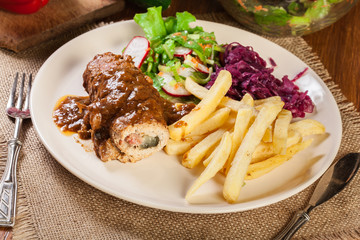 Pork roulade with french fries with salad