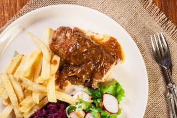 Pork roulade with french fries with salad