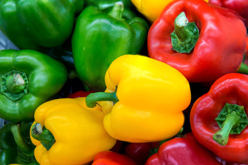 Red and yellow and Green sweet peppers. Pile Three sweet peppers on a wooden background, Cooking vegetable salad . Colorful sweet bell peppers, natural background.