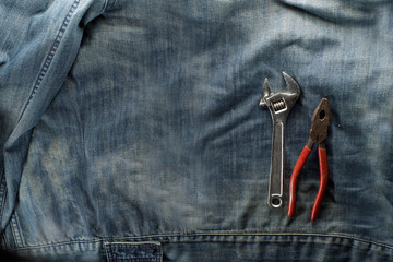 Spanner, adjustable wrench, wire cutters, pliers, isolated on labor jacket. Labor day concept.