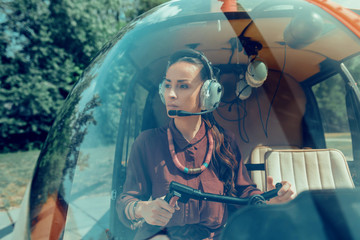 Concentrated good-looking female pilot wearing needed equipment - obrazy, fototapety, plakaty
