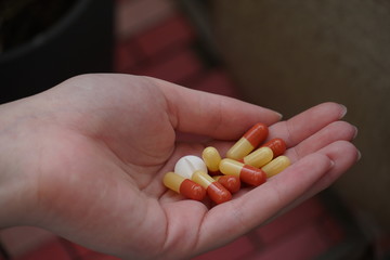 Female hand holding medicine or pills