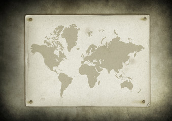 Vintage world map parchment nailed to a wall