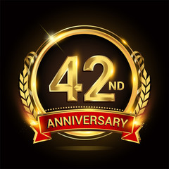 42 golden anniversary logo, with shiny ring and red ribbon, laurel wreath isolated on black background, vector design