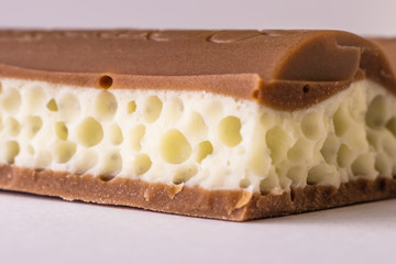 Porous chocolate mix of milk and white close-up. The photo is suitable as a background. Macro