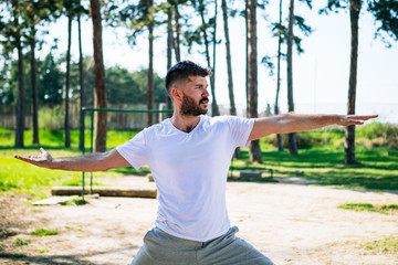 Young man doing yoga pose in the park