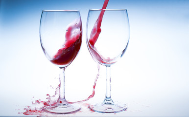 Splash red wine glass against a white background