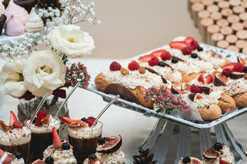 Candybar in a restaurant. Decorated white table fool of sweet pastry