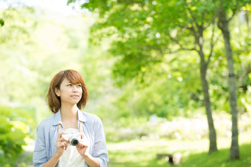 カメラを持ち微笑む女性