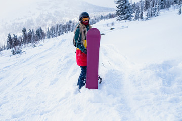 Snowboarder freerider woman on a snowy slope in the mountains.