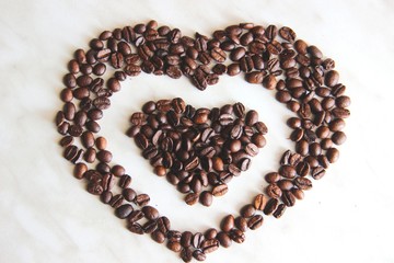 coffee beans after roasting. coffee beans in the shape of a heart in the heart, after roasting on the table