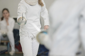 Two young women fencers practicing fencing duel