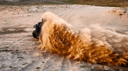 Racing in the sand on a four-wheel drive quad. © Bondariev Volodymyr.