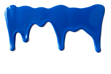 Blue paint leaking down white background. Close up.