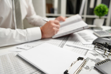 Businessman working at office and calculating finance, reads and writes reports. Business financial accounting concept.