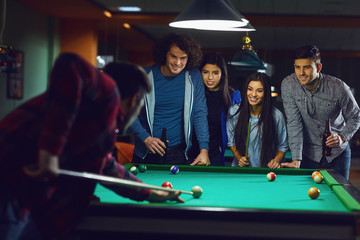 Obraz premium Friends play billiards in bar.