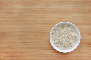 Dried shredded fish floss in white bowl on wooden board background with copy space.